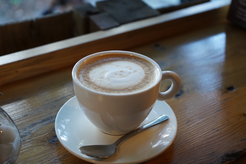 a cup of coffee on a saucer with a spoon