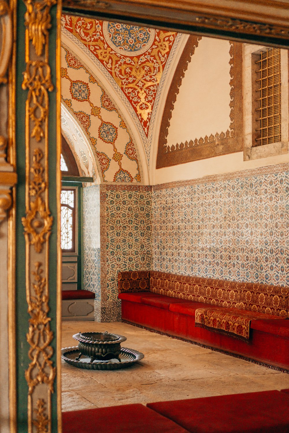 a room with a red rug and a red bench