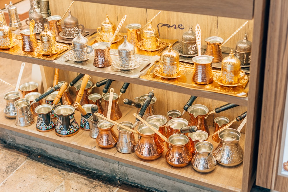 a shelf is filled with old pottery