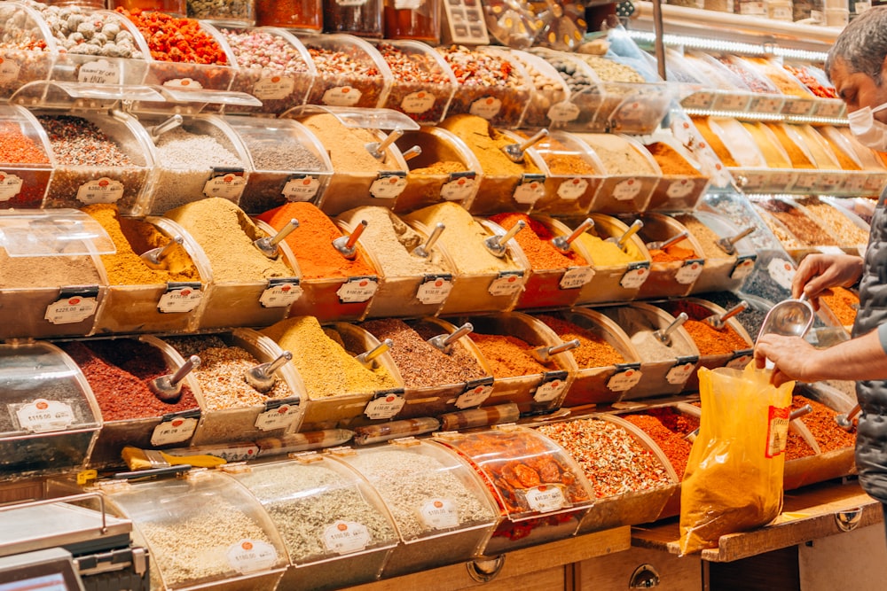 a person looking at a display of cheeses