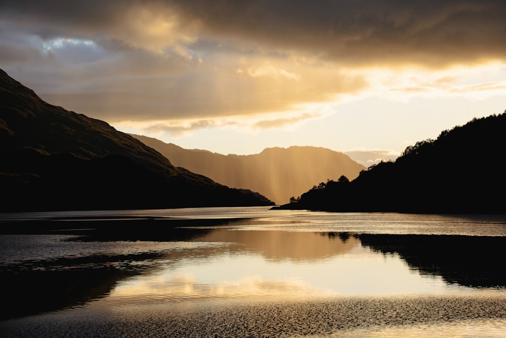 a body of water with mountains in the background