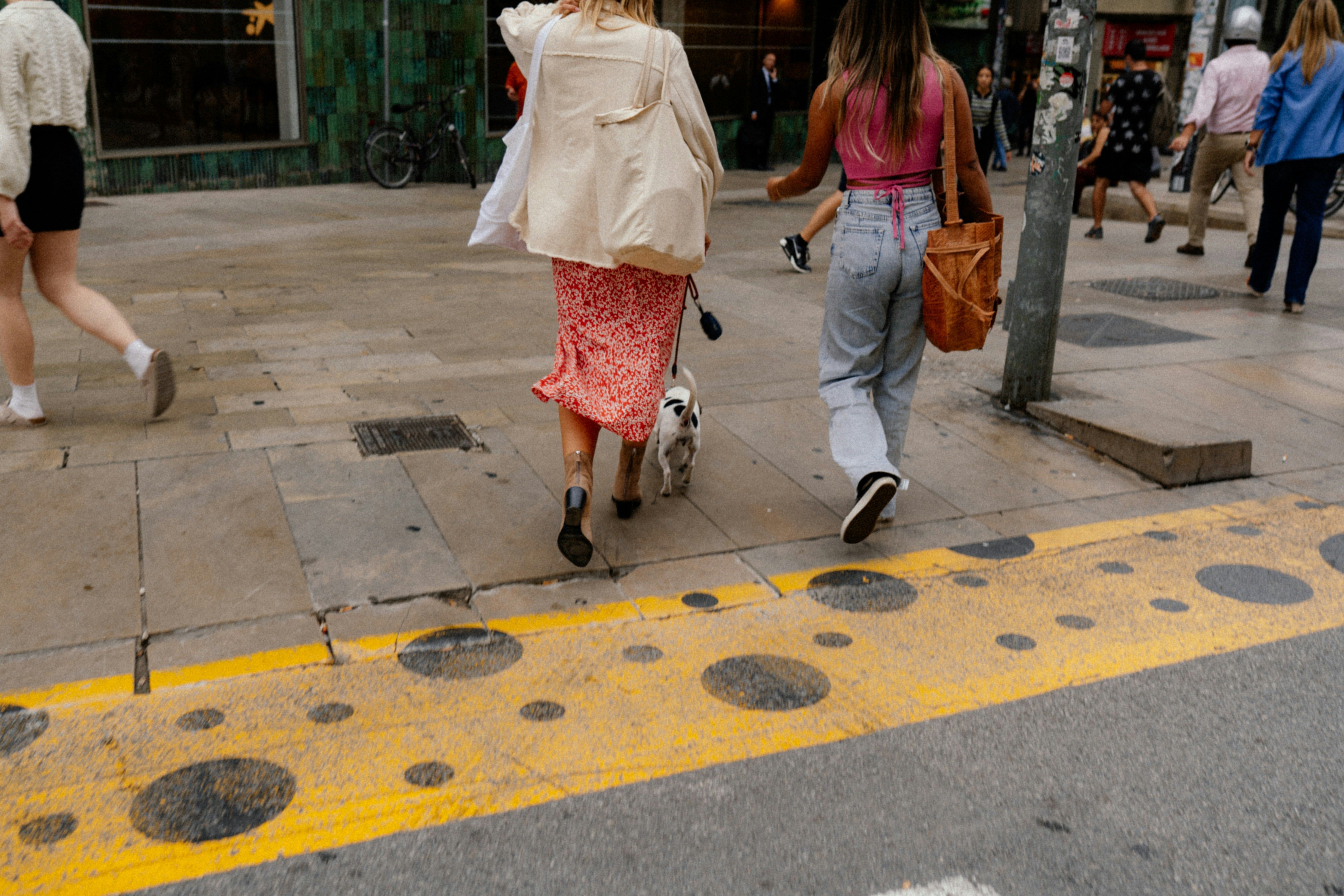 a group of people walking on a sidewalk