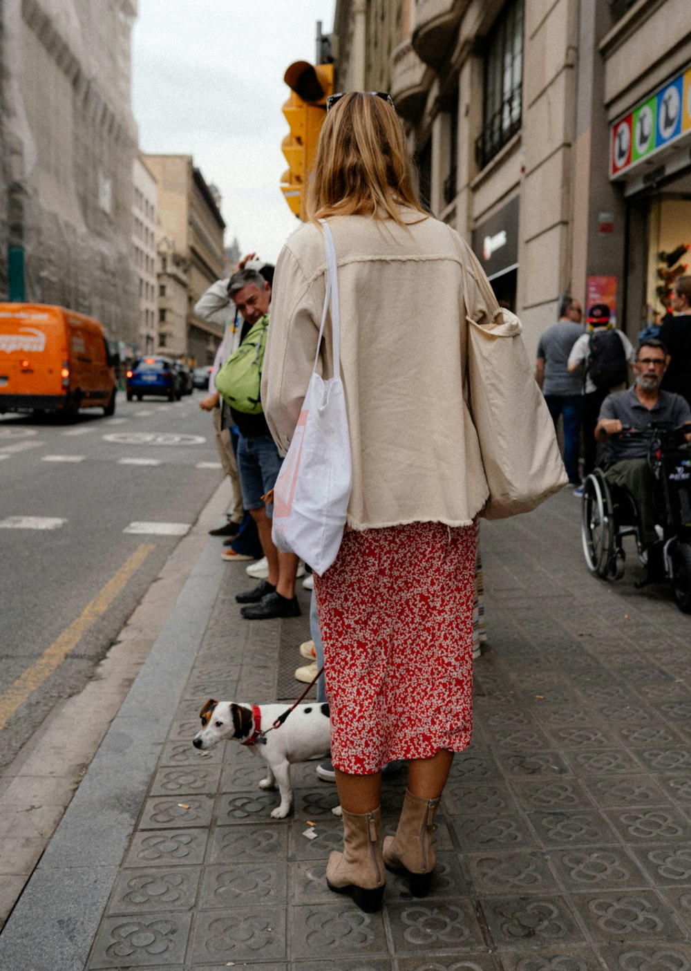 a woman walking a dog on a sidewalk