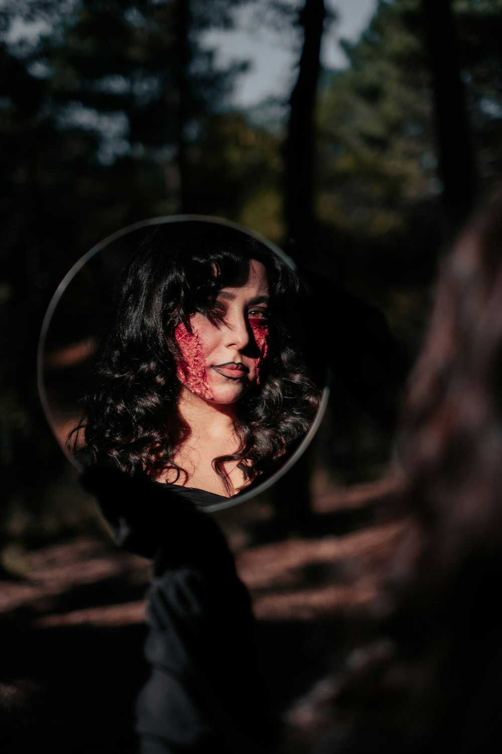 a person with red paint on the face in the woods