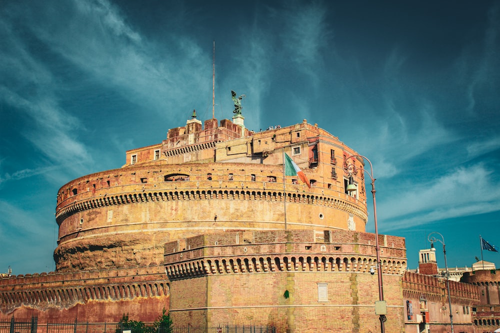 a large building with flags on it with Castel Sant'Angelo in the background