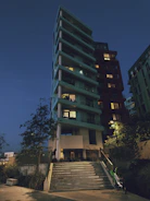 Elegant modern residential building with silver and dark green accents at dusk.