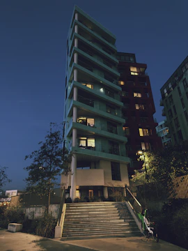 Elegant modern residential building with silver and dark green accents at dusk.