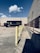 A delivery truck parked outside a modern warehouse, ready for loading.
