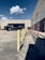 A delivery truck parked in front of a warehouse during daylight.