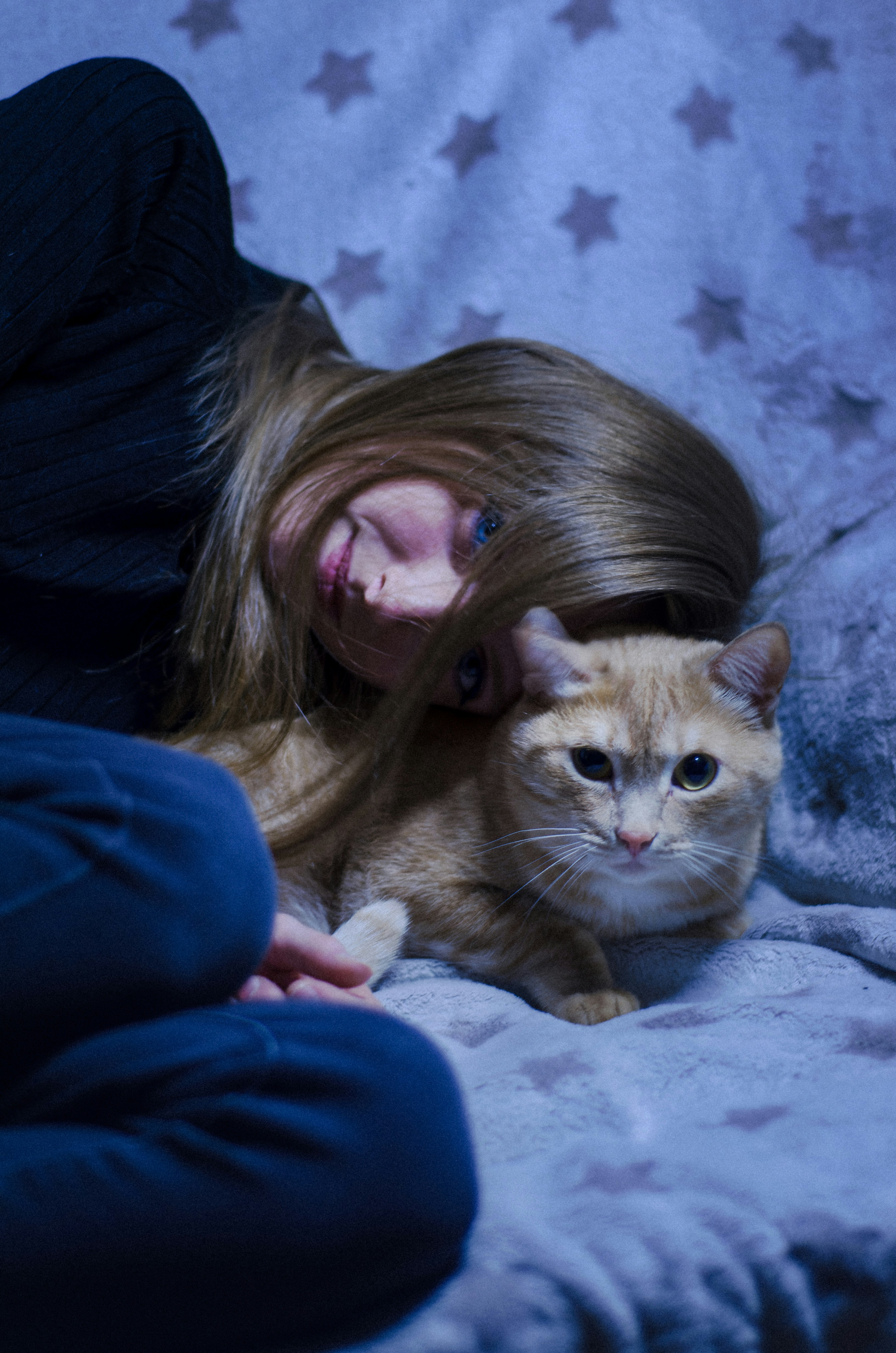 a person lying on a bed with a cat