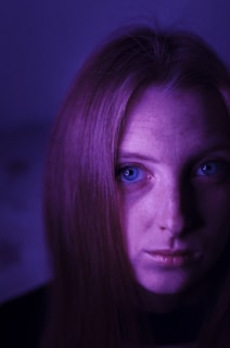 A close-up portrait bathed in soft purple lighting, capturing raw emotion