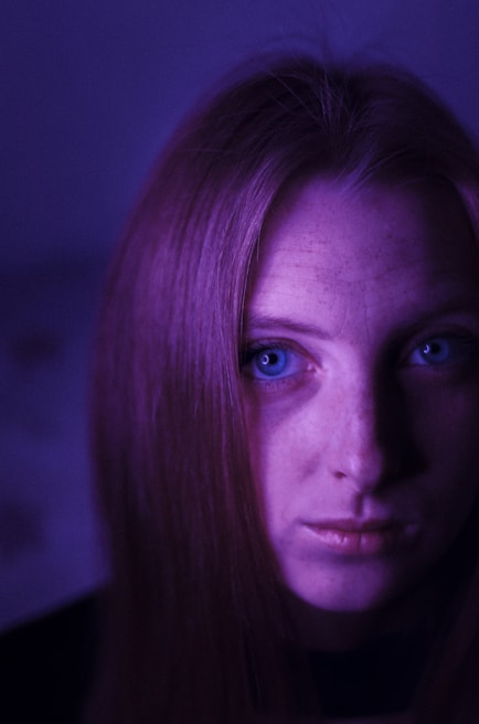 A close-up portrait bathed in soft purple lighting, capturing raw emotion