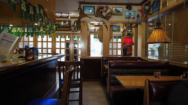 Cozy seafood restaurant interior with rustic wooden tables and a vibrant coffee bar in the background.