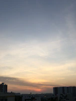 A serene sunset over a city skyline, symbolizing hope and new beginnings for migrants abroad.