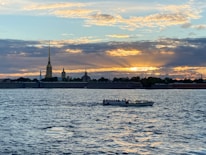 A scenic view of the Nile River with a traditional felucca boat sailing at sunset.