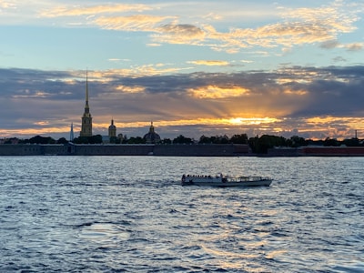 A scenic view of the Nile River with a traditional felucca boat sailing at sunset.
