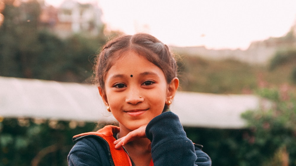 a girl smiling with her hand on her chin