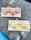 Four glasses of an amber-colored drink with ice and lemon slices are placed on a white rectangular tray. Below, four glasses containing a yellow drink with ice and lime wedges are also on a similar tray. Both trays are set on a dark, marble-like tabletop.