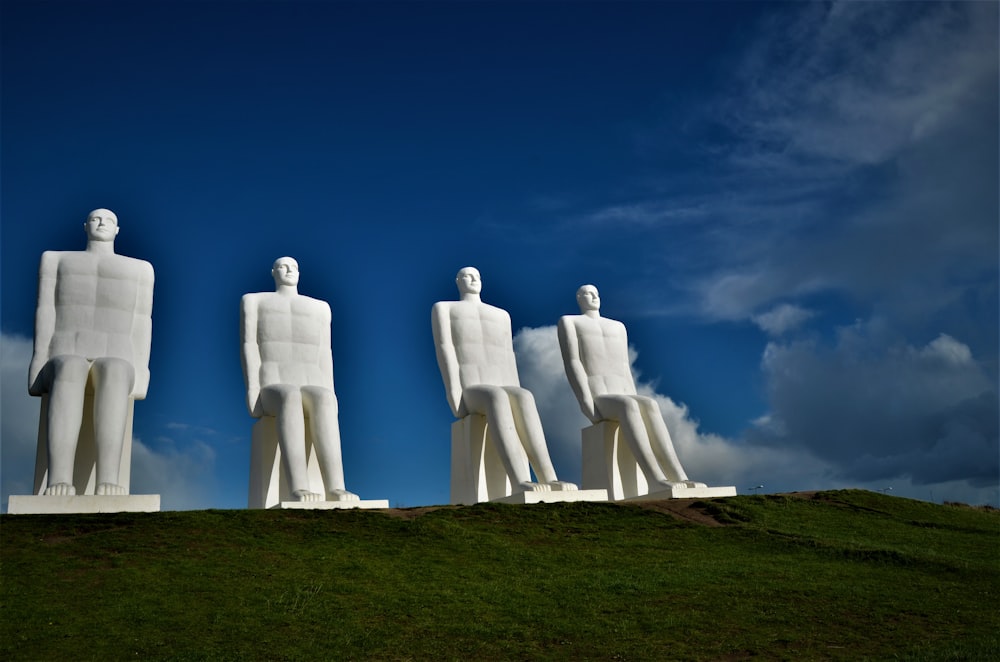 a group of statues on a grassy hill