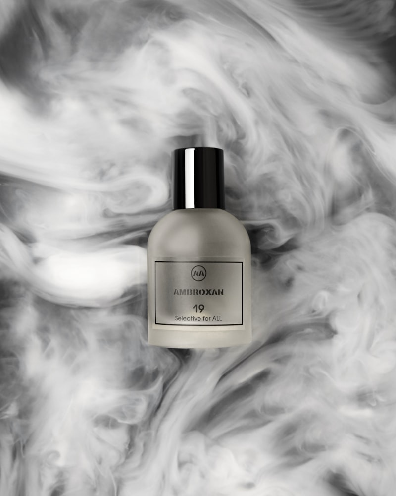 Flacon de parfum minimalist fotografiat în lumină moale