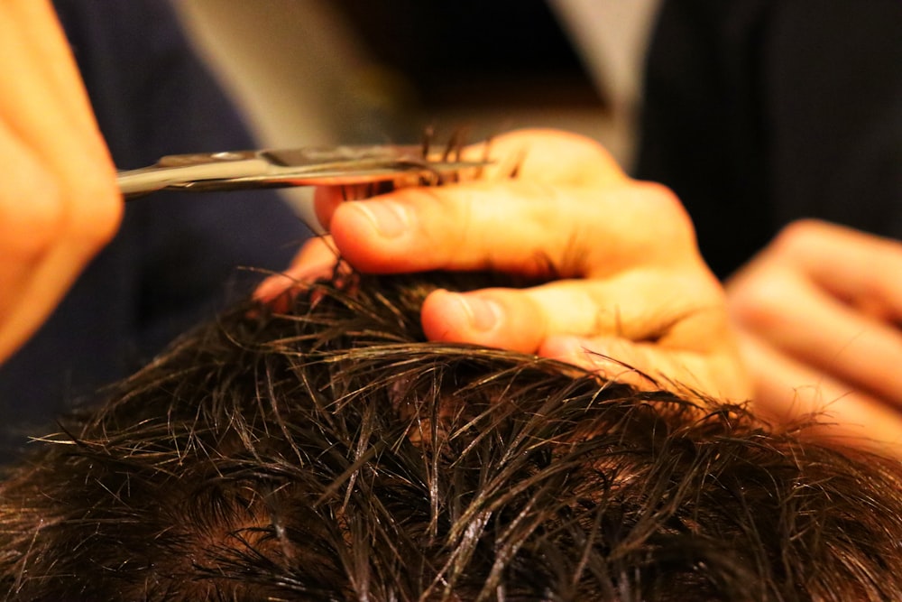 a person cutting a hair