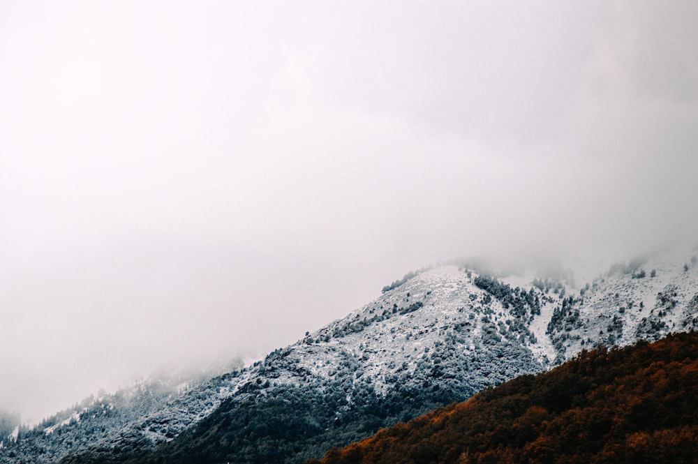 a snowy mountain with a foggy sky