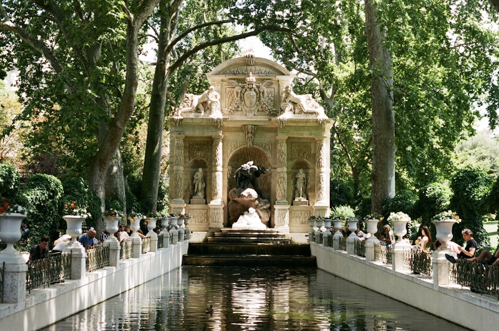 a fountain with statues and trees around it