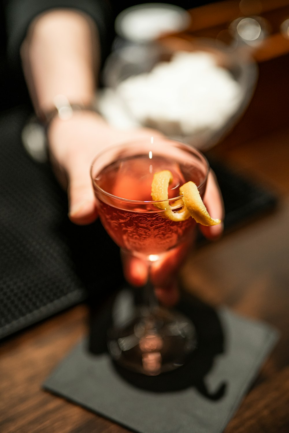 a hand holding a glass of liquid