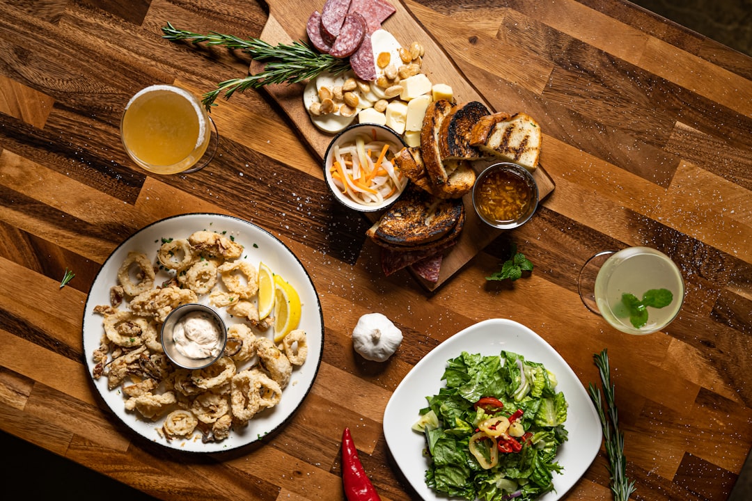 a table with plates of food and cups of liquid,