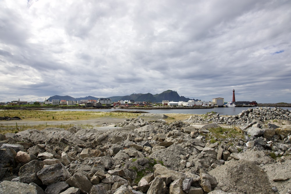 a rocky beach with a lighthouse in the distance