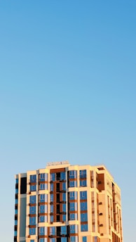 A completed commercial building gleaming under a clear blue sky.