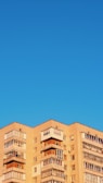 Multi-story residential building under clear blue sky.
