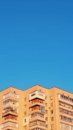 Multi-story residential building under clear blue sky.