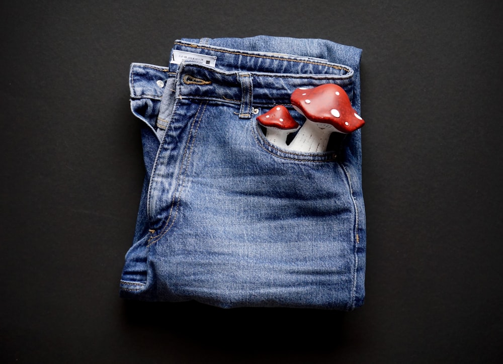 a pair of jeans with a red heart on the front
