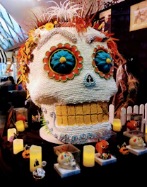 Gallery-style display of various handcrafted skulls with desert tones.