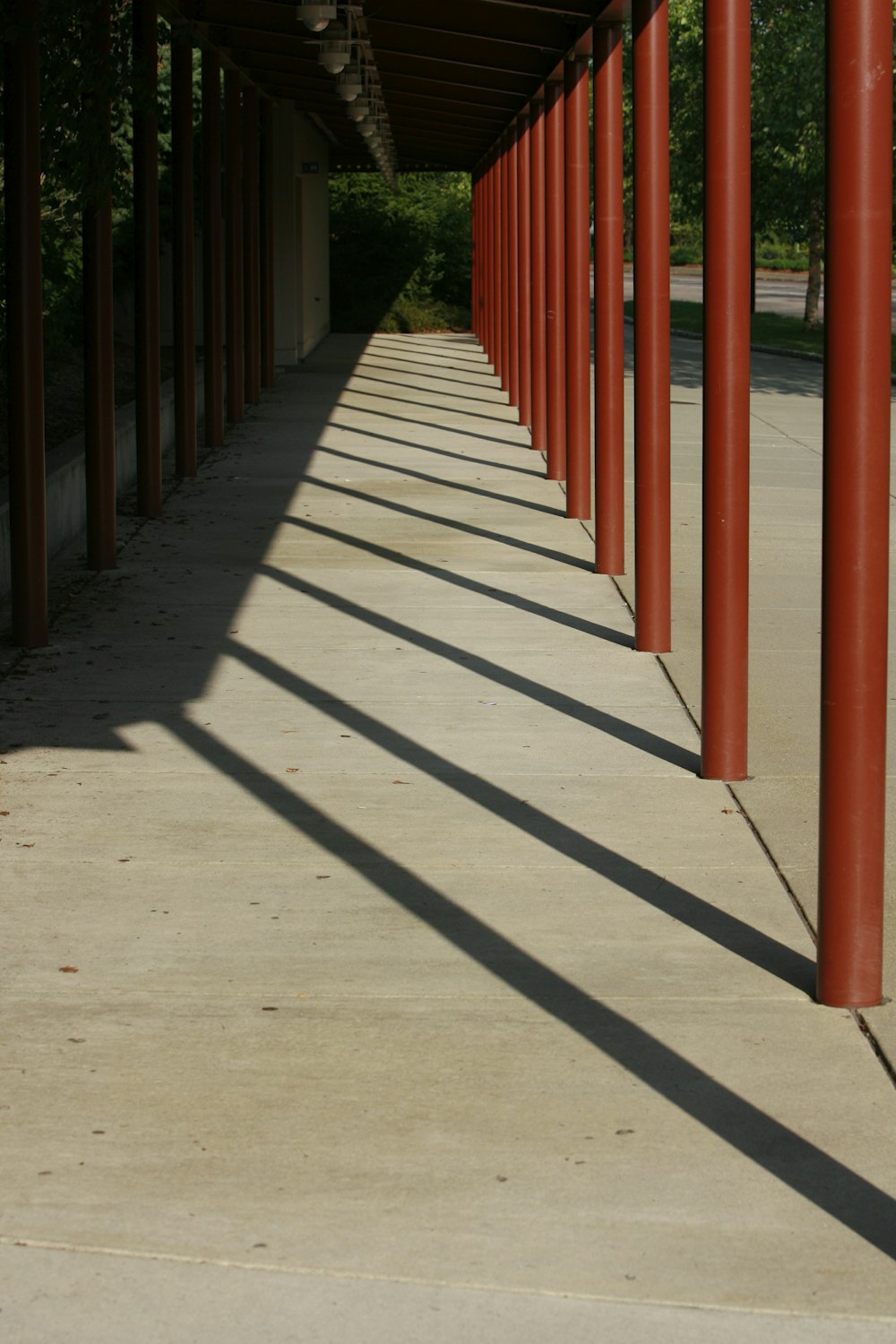 a walkway with red poles