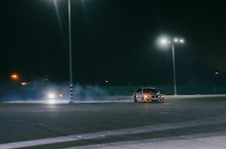 A high-performance street car drifting on an empty city road at dusk, smoke trailing from the tires.