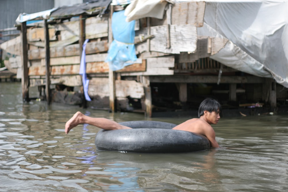 Ein Mann in einem Fluss mit einem großen Fisch im Maul