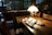 A cozy reading nook with a rustic wooden table and a stylish lamp.