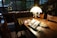 A cozy reading nook with a rustic wooden table and a stylish lamp.