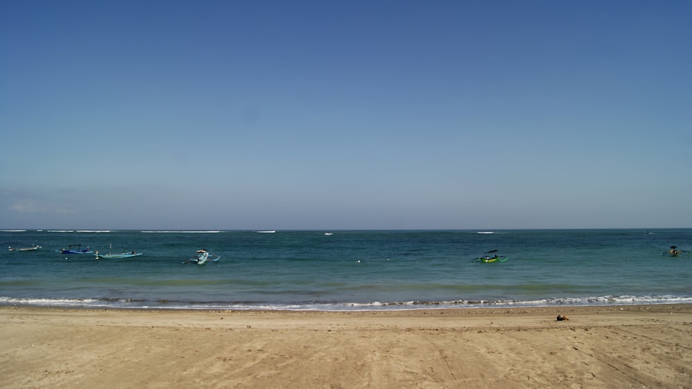 Una playa con barcos en el agua