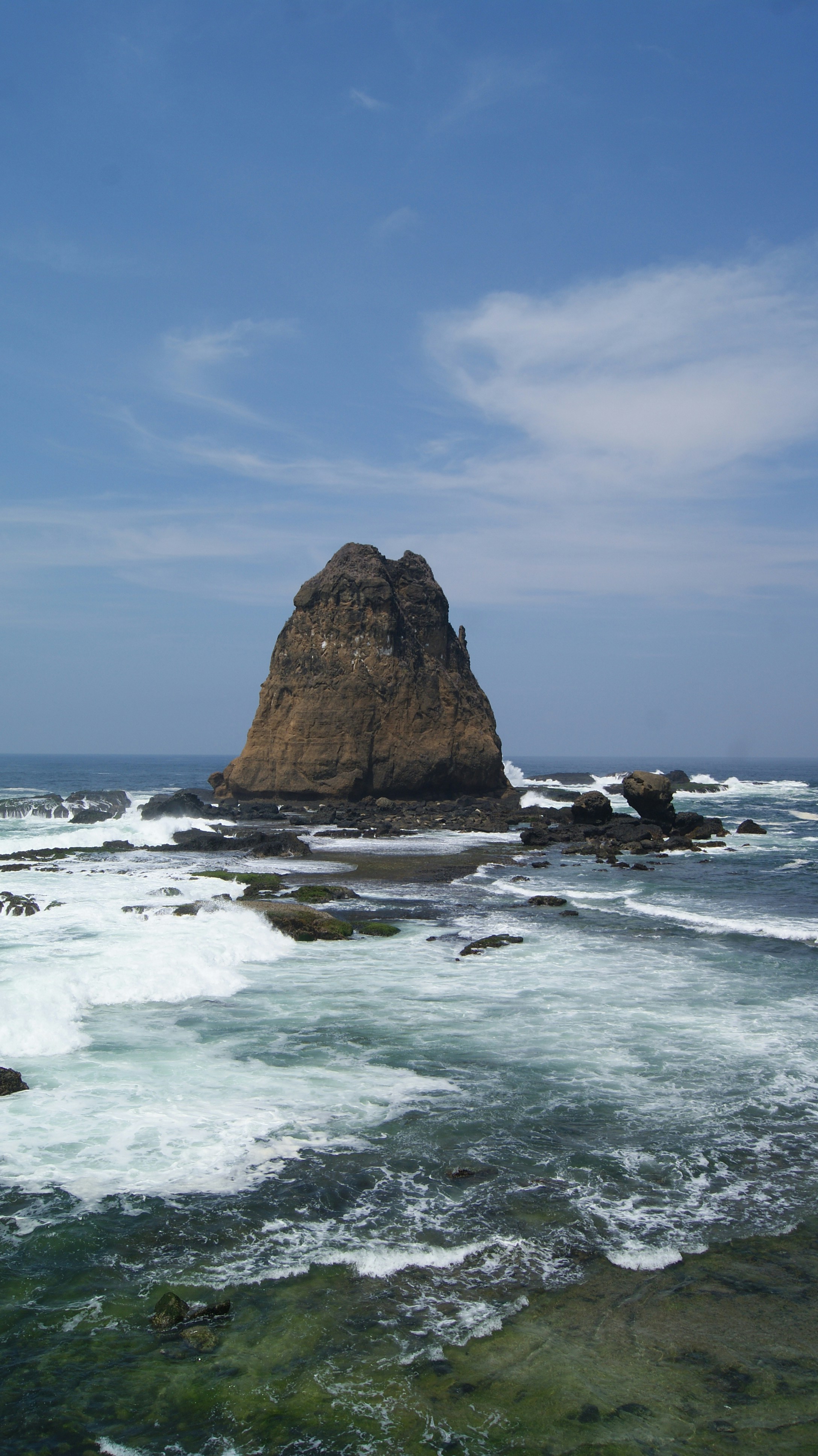 a rocky beach with waves crashing against it