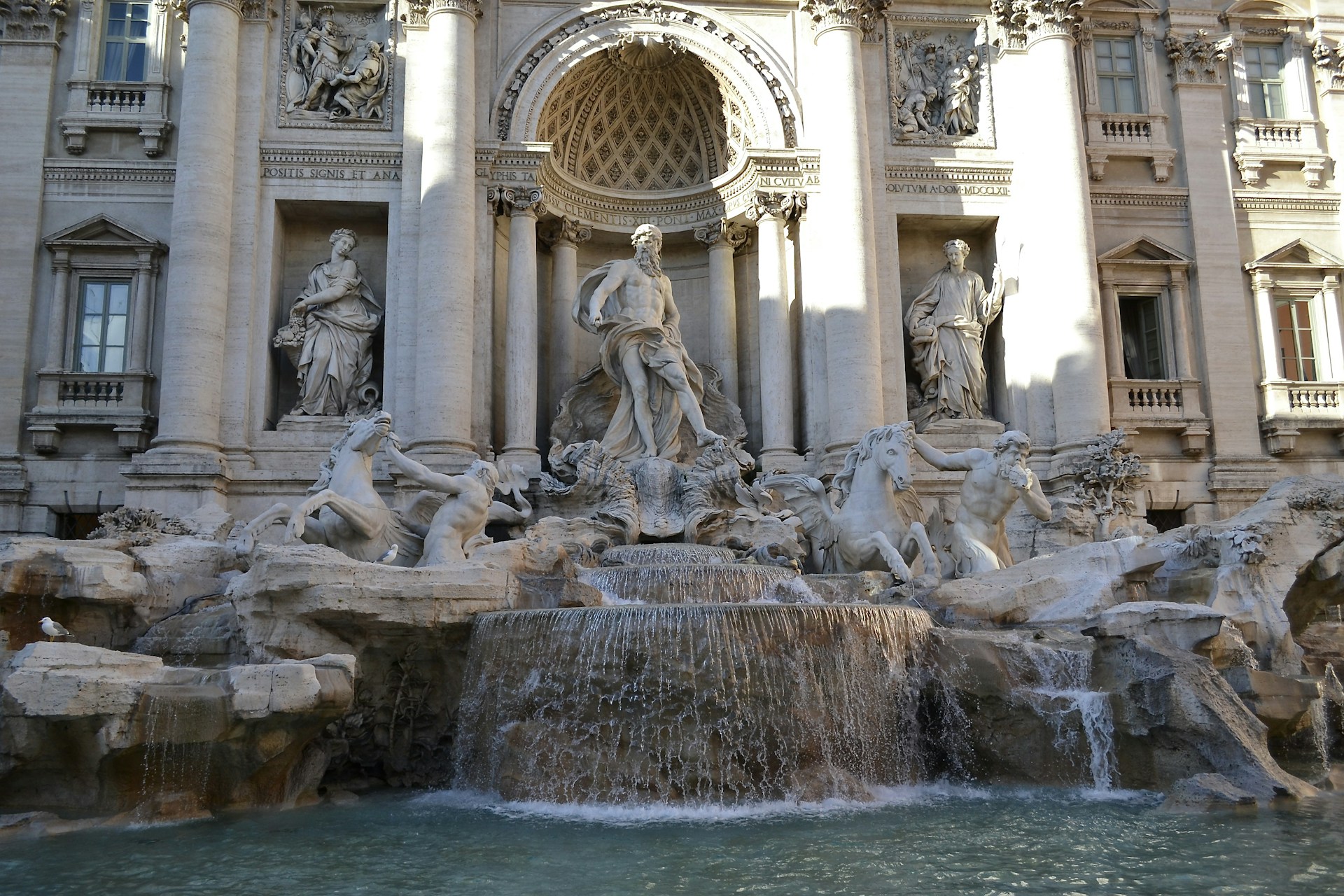 a fountain with statues in front of Trevi Fountain