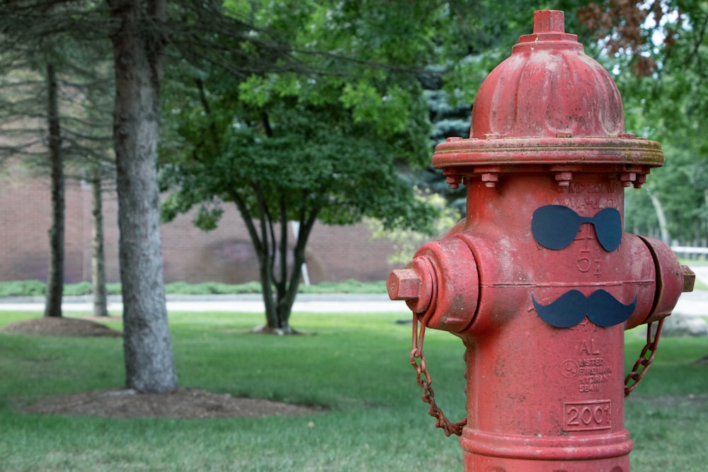 une borne d’incendie rouge avec un visage de dessin animé dessus
