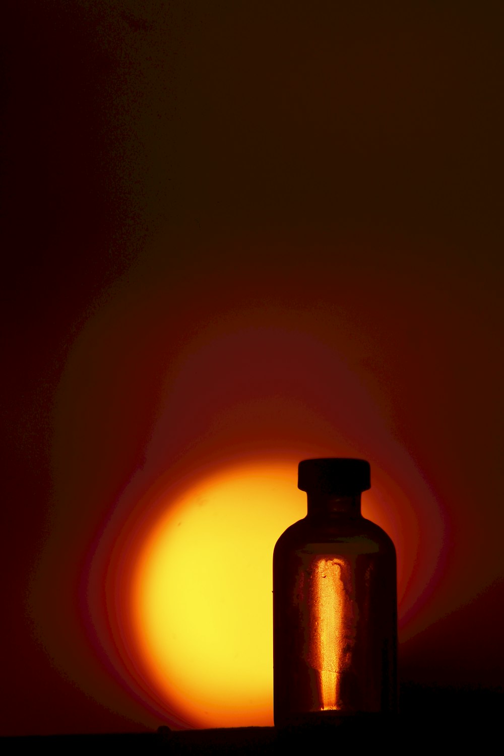 a bottle of oil with a fire in the background