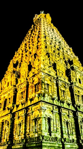 An intricately carved ancient temple replica illuminated by soft alien light.