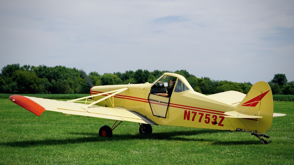 a small yellow plane on the grass