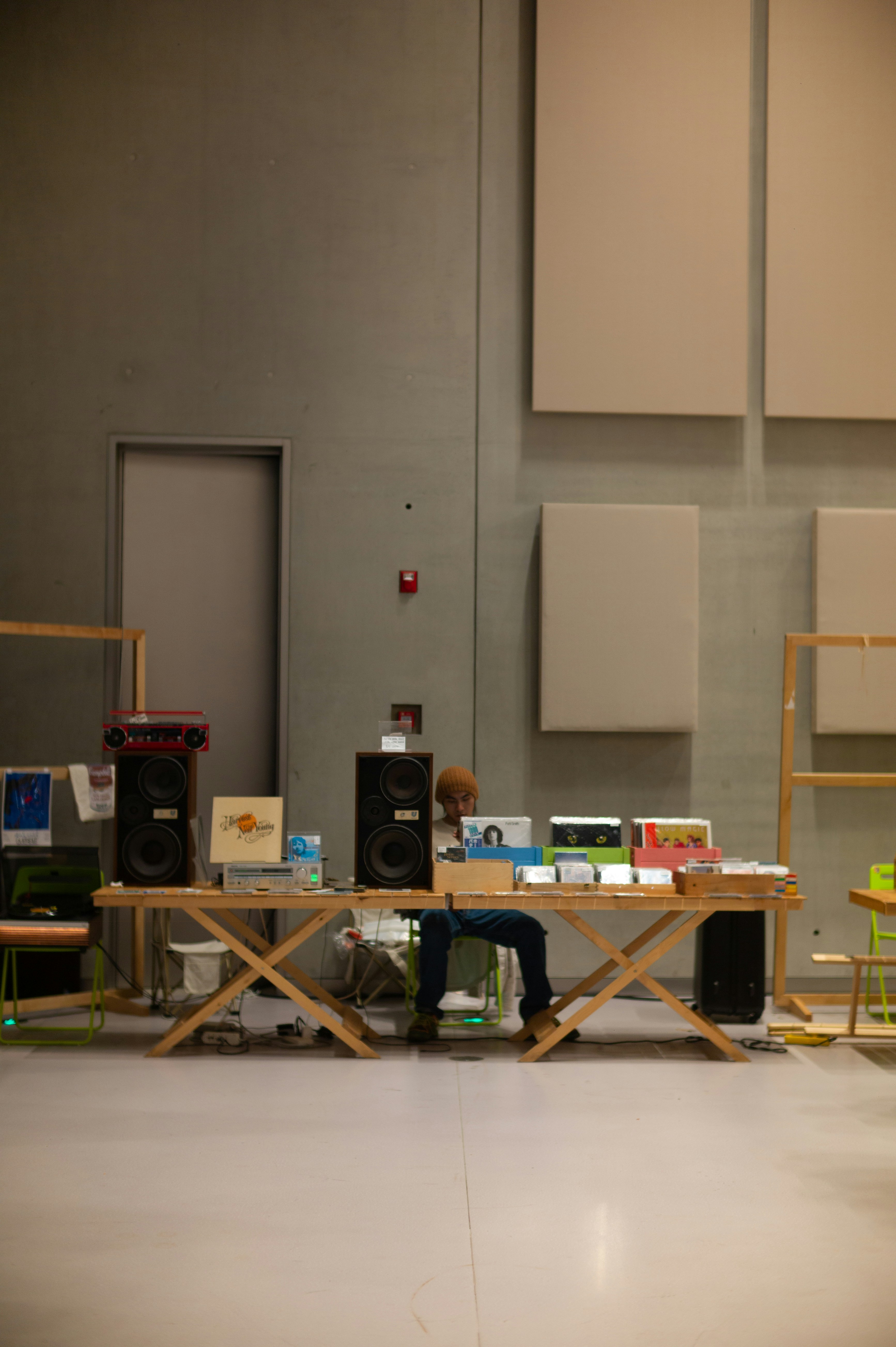 a person sitting at a desk with a computer and speakers
