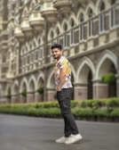 A smiling man wearing a personalized T-shirt with a minimalist logo on a city street