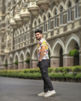 Close-up of a stylish man wearing a vibrant, uniquely designed t-shirt outdoors.